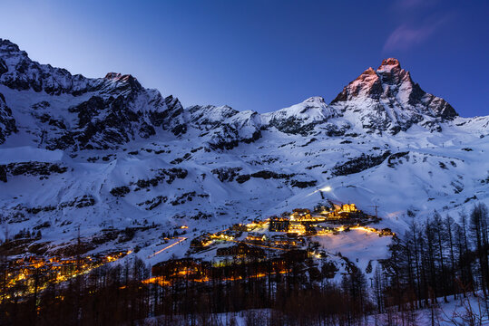 City of Cervinia in a blue hour with orange top of Matterhorn.