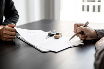 An employee of the rental car company submits a car rental agreement for the renter to sign the...