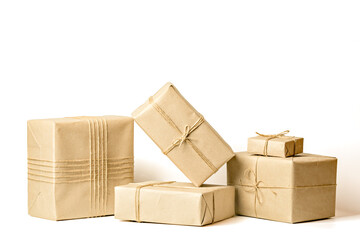 Gift boxes wrapped in recycled craft paper tied with twine on white background