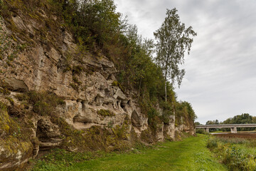 Fototapeta na wymiar Exposed rocky cliff with caves in Tori, Estonia. Local name - Devil's caves