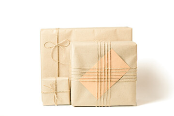 Gift boxes wrapped in recycled craft paper tied with twine on white background
