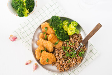 Homemade chicken nuggets with buckwheat and vegetables in a plate