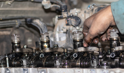 The mechanic is checking the engine.