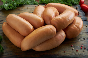 Sausage lies with spices on a wooden background