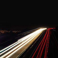 Night mountain serpentine road, long exposure. City lights below