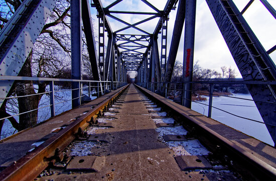 an abandoned railway bridge over a frozen river