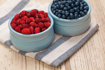 Bilberry and strawberry on table, organic food concept