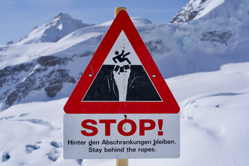 Stop sign danger of crevasses, text stay behind the ropes, Jungfraujoch, Switzerland.