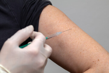 Vaccination with a syringe in the upper arm