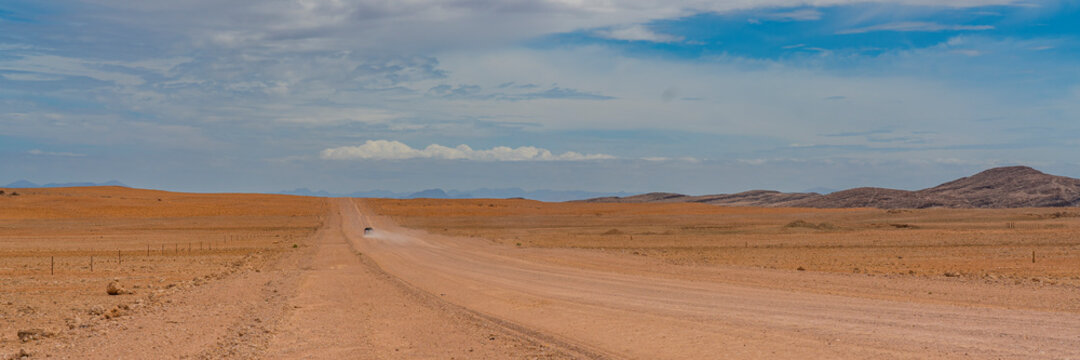 Landscape with road and a car at Namib-Naukluft National Park , s a national park of Namibia, panorama view