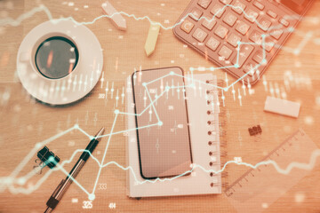 Multi exposure of forex graph hologram over desktop with phone. Top view. Mobile trade platform...
