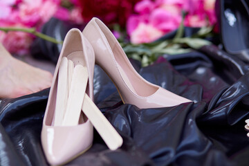 Peones and putty knife or spatulla for shugaring procedure  on a pink background with shoes. Women concept