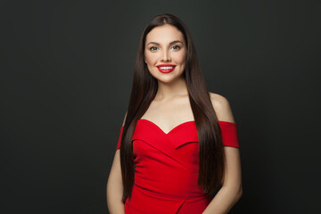 Fototapeta premium Happy brunette woman with long healthy straight hair smiling on black background