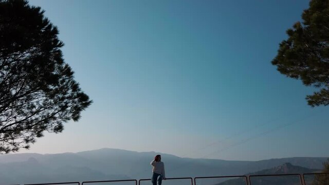 Silhouette ragazza sulla ringhiera con cielo blu
