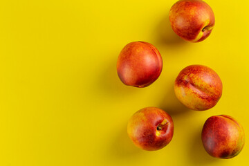 Ripe nectarine on a yellow background. Fresh fruits.