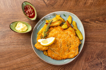 schnitzel with chips on a blue plate
