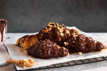 Dark chocolate croissants with nut and flower of salt on top in vintage dark stone background. Tasty and freshly croissants. 