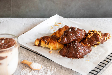 Dark chocolate croissants with nut and flower of salt on top in vintage dark stone background. Tasty and freshly croissants. 