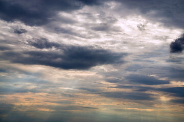 Obraz premium The sun's rays break through the clouds at sunset.