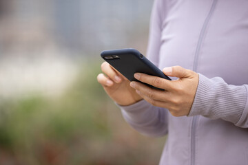 Asian woman using smartphone outdoors