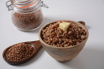 Bowl of tasty buckwheat porridge with piece of butter on the top