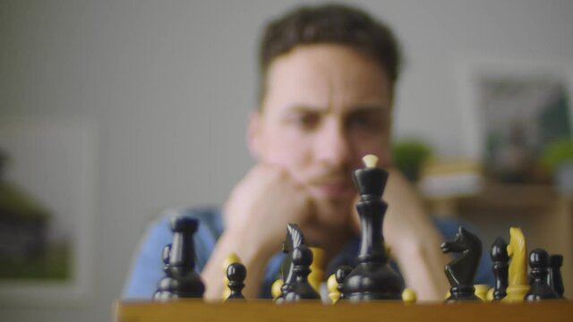 A young handsome guy is thinking about the next move in a difficult game