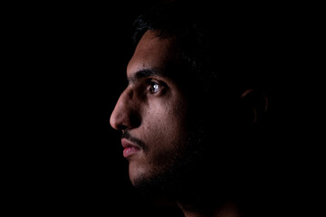 Portrait of middle eastern guy in a dark room - Powered by Adobe