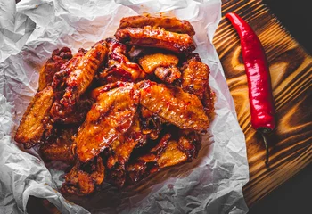 Foto op Plexiglas fried chicken wings with sweet chili sauce on white paper © pavel siamionov
