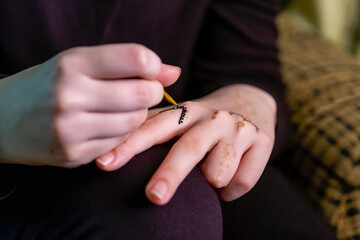 Drawing henna on a beautiful hand
