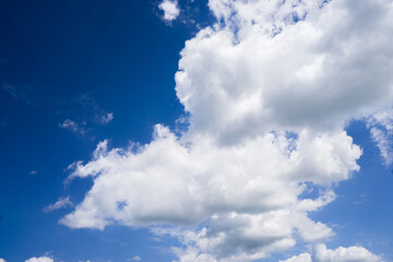 Obraz premium Bright cumulus clouds against a blue sky.