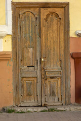 Dried cracked old wooden double-wing door in an old building. Close-up.