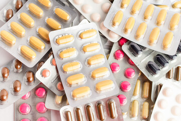 Close up of different medicine pills, tablets and vitamins isolated on white background, pharmaceutical picture taken with soft focus.