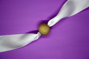 Wooden bead on a purple background. Craft.