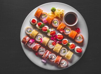 set of sushi roll with salmon, avocado, cream cheese, cucumber, rice, tuna in plate on black background