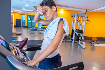 Boy training on the treadmill for increasing his stamina and tired after long term of training
