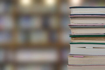 Stacking books in library room, bookshelf with blurred work and education background, back to school concept