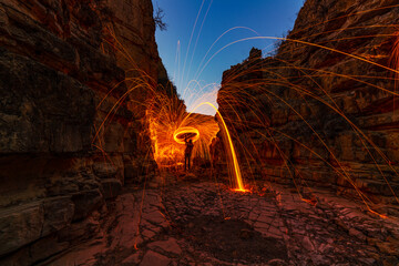 Fire show, swirl, steel wool. Sparks from a metal in beautiful the canyon.