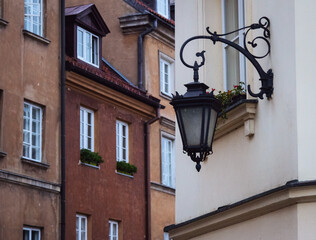 Old lantern on the wall of an old house on the background of the city © Alexander
