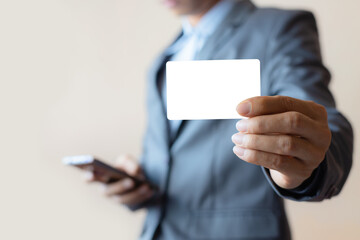 business man using smart phone and holding business card concept for e-commerce with shopping or electronic banking and finance web internet online.