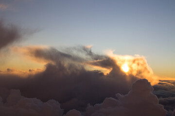 spectacular sunset seen from an airplane with clouds in the foreground and in the distance
