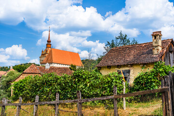 Rural countriside landscape of Saschiz village with the medieval saxon fortified church in the background in Saschiz, Mures county, Transylvania, Romania