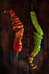 Green and red chili peppers cut on a wooden table