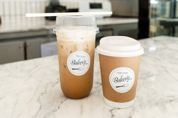 Two cup of hot and iced coffee on white marble table is ready for take away.
