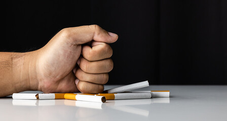 The young man smashed and smashed the cigarette with his hand. He wants to quit smoking for good health.