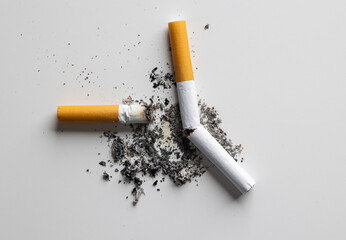 The smoking cigarette is left on the floor. Cigarette butt on the table