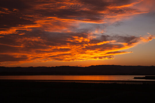 潟湖を照らす美しいオレンジ色の夕日 | 福島県相馬市の松川浦 © 友紀 白田