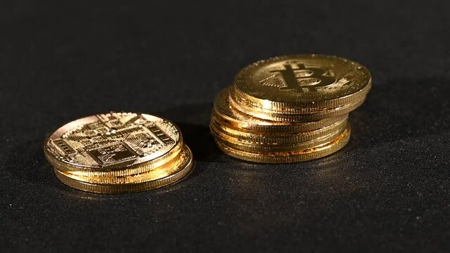 Golden bitcoin physical coin rolling over black