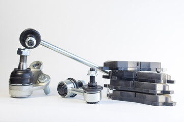 Brand new set of car chassis spare parts, car anti-roll bar, ball joint, brake pads. Car spare parts on white background