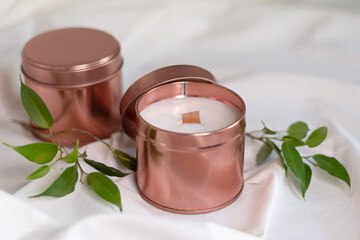 Homemade organic scented soy candle with a wooden wick in rose gold container.