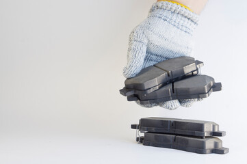 Brand new brake pads for a car on a white background in a mechanic's hand. Brake pad - part of the...